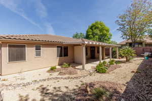 Back of house featuring a patio area, stucco siding, a fenced backyard, and a tiled roof