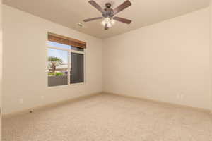 Spare room with light carpet and a ceiling fan