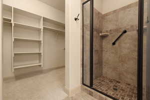 Full bath with a stall shower and a spacious closet