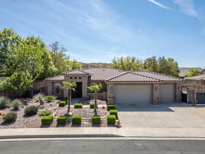 View of front of house featuring an attached garage, stone siding, driveway, stucco siding, and a tile roof