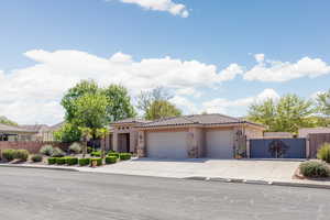 Mediterranean / spanish-style house with a garage, a tiled roof, stucco siding, a gate, and concrete driveway