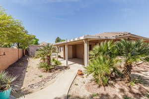 Rear view of property featuring a fenced backyard, stucco siding, and a tiled roof