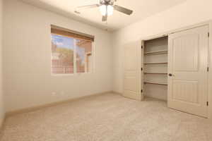 Unfurnished bedroom featuring light carpet, ceiling fan, and a closet