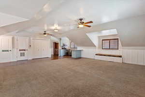 Additional living space with lofted ceiling, ceiling fan, and dark carpet