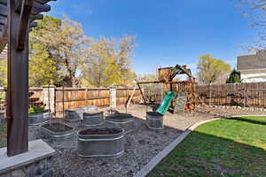 Fenced backyard with a playground and a patio