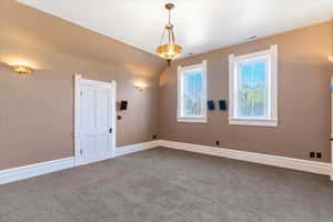 Unfurnished room with carpet floors and vaulted ceiling