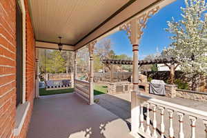 Fenced backyard featuring a patio area, a wooden deck, a pergola, and exterior kitchen