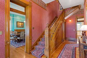 Stairs with wood finished floors and wallpapered walls