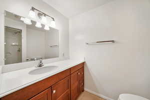 Bathroom featuring vanity, light tile patterned flooring, and a shower