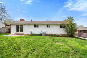 Back of property featuring a patio area, a chimney, and board and batten siding