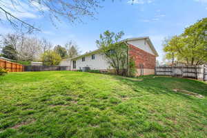 Back of property with a fenced backyard and brick siding