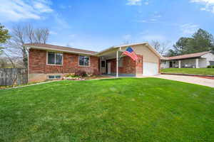 Ranch-style home featuring brick siding, driveway, and a garage