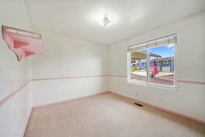 Spare room with light carpet and baseboards
