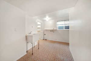 Laundry area with baseboards and light colored carpet