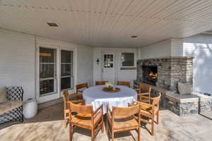View of patio / terrace with outdoor dining area and an outdoor stone fireplace