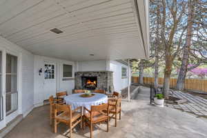 View of patio / terrace with outdoor dining area and an outdoor stone fireplace