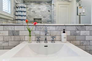 Bathroom view of double vanity and a tile shower