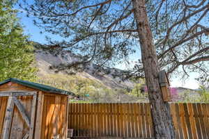 Fenced yard with a storage unit and a mountain view