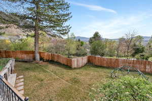 Fenced backyard featuring a mountain view