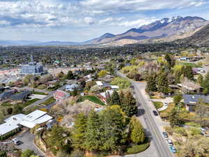 Aerial view of property and surrounding area with a mountain backdrop and nearby suburban area