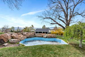 View of grassy yard featuring a mountain view and an outbuilding