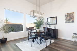 Dining area featuring dark wood finished floors, healthy amount of natural light, and hanging lights