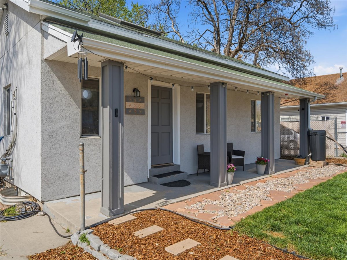 Entrance to property featuring stucco siding and a porch