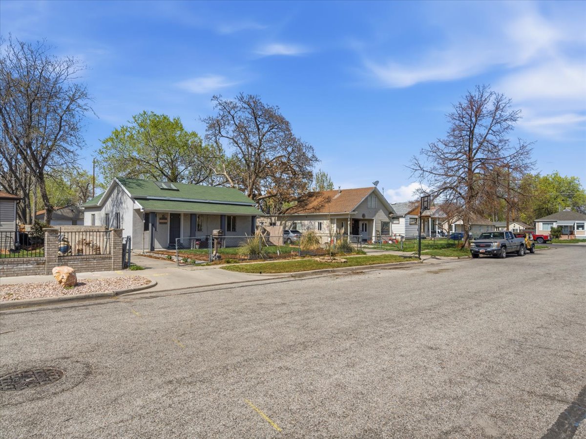 Bungalow-style house featuring a porch, a fenced front yard, a residential view, and a gate