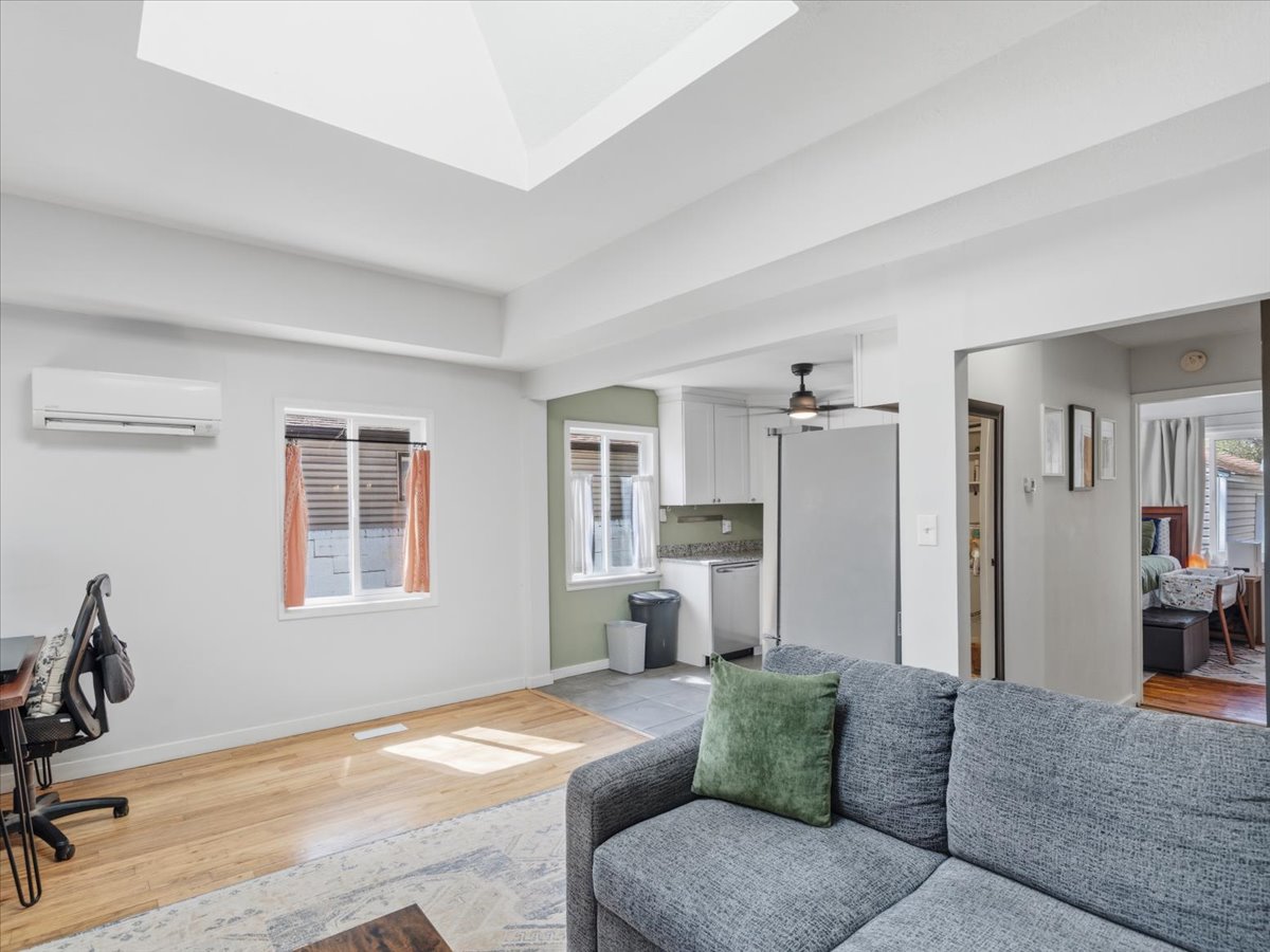 Living area featuring light wood-style flooring, a desk, and a ceiling fan