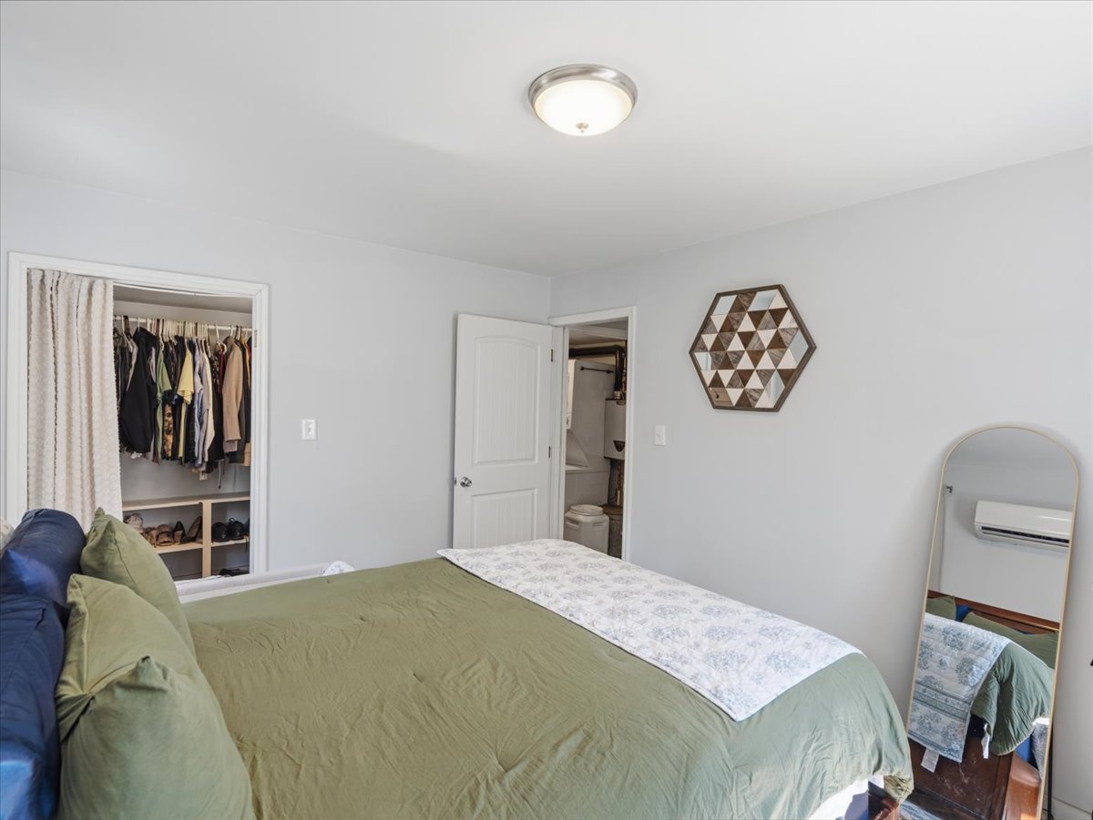 Bedroom with a wall mounted mini split and a closet