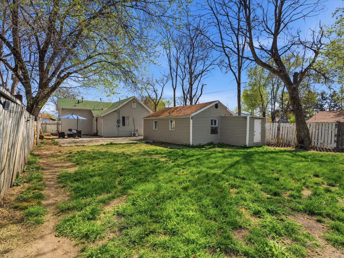 Back of property featuring a fenced backyard and a patio