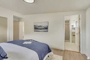 Bedroom featuring light wood finished floors and ensuite bath