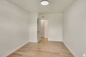 Spare room with light wood-style floors and baseboards