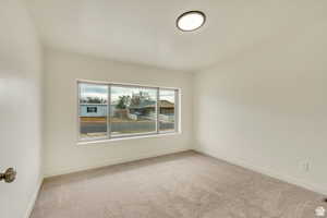Unfurnished room featuring light colored carpet and baseboards