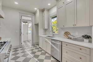 Kitchen featuring light flooring, stainless steel appliances, light stone countertops, recessed lighting, and white cabinetry