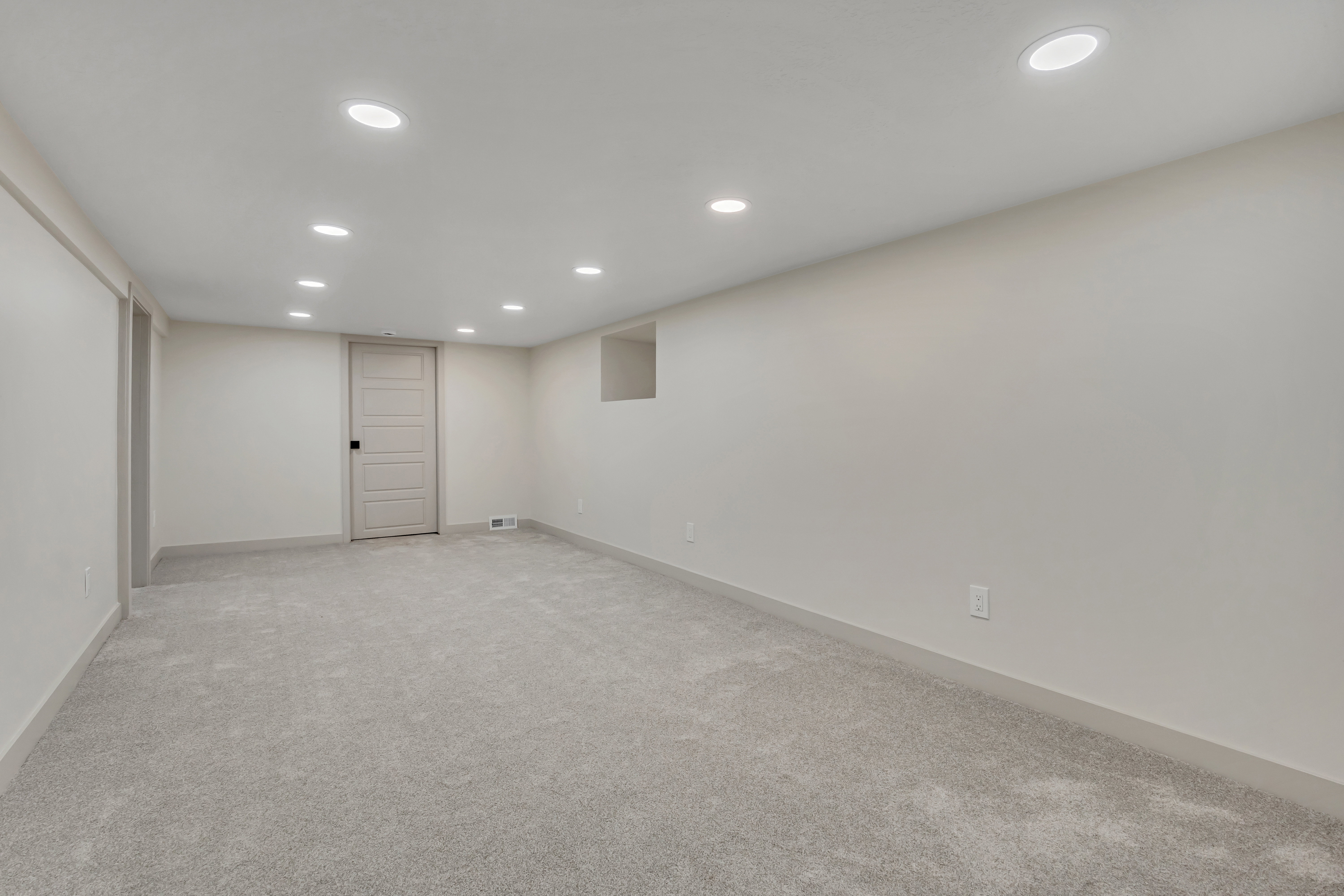 Finished below grade area featuring recessed lighting and light colored carpet