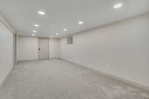Finished below grade area featuring recessed lighting and light colored carpet