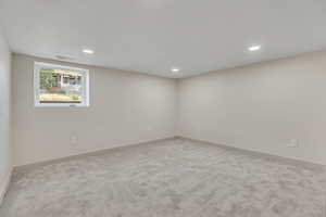 Empty room featuring light carpet and recessed lighting