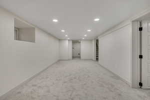 Finished basement with recessed lighting and light colored carpet