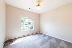 Spare room featuring a ceiling fan and light carpet