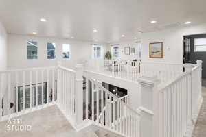Hall featuring carpet flooring, an upstairs landing, and recessed lighting