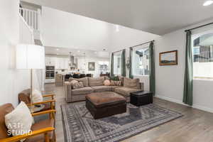 Living area with dark wood-type flooring, recessed lighting, and a high ceiling