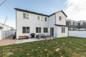 Rear view of property with a fenced backyard, a patio, outdoor furniture, and stucco siding