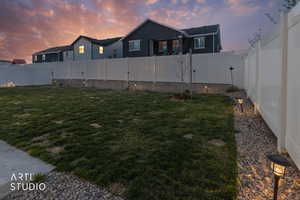 Yard at dusk with a fenced backyard