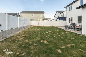 Fenced backyard featuring a patio area, a residential view, and an outdoor hangout area