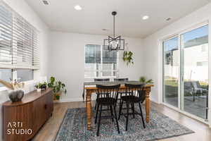 Dining room with hanging lights and light wood-style floors