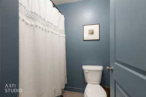 Full bathroom featuring a shower with shower curtain and light tile patterned floors