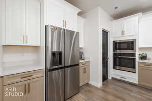 Kitchen featuring stainless steel appliances, light wood-style flooring, and light stone countertops