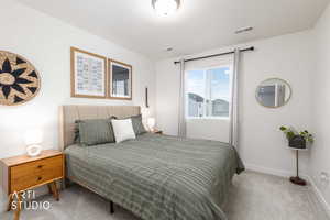 Bedroom with light colored carpet and baseboards