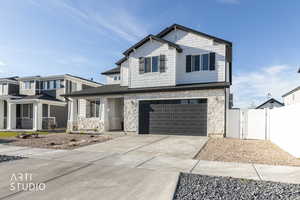Craftsman inspired home featuring stone siding, a gate, driveway, a garage, and a porch
